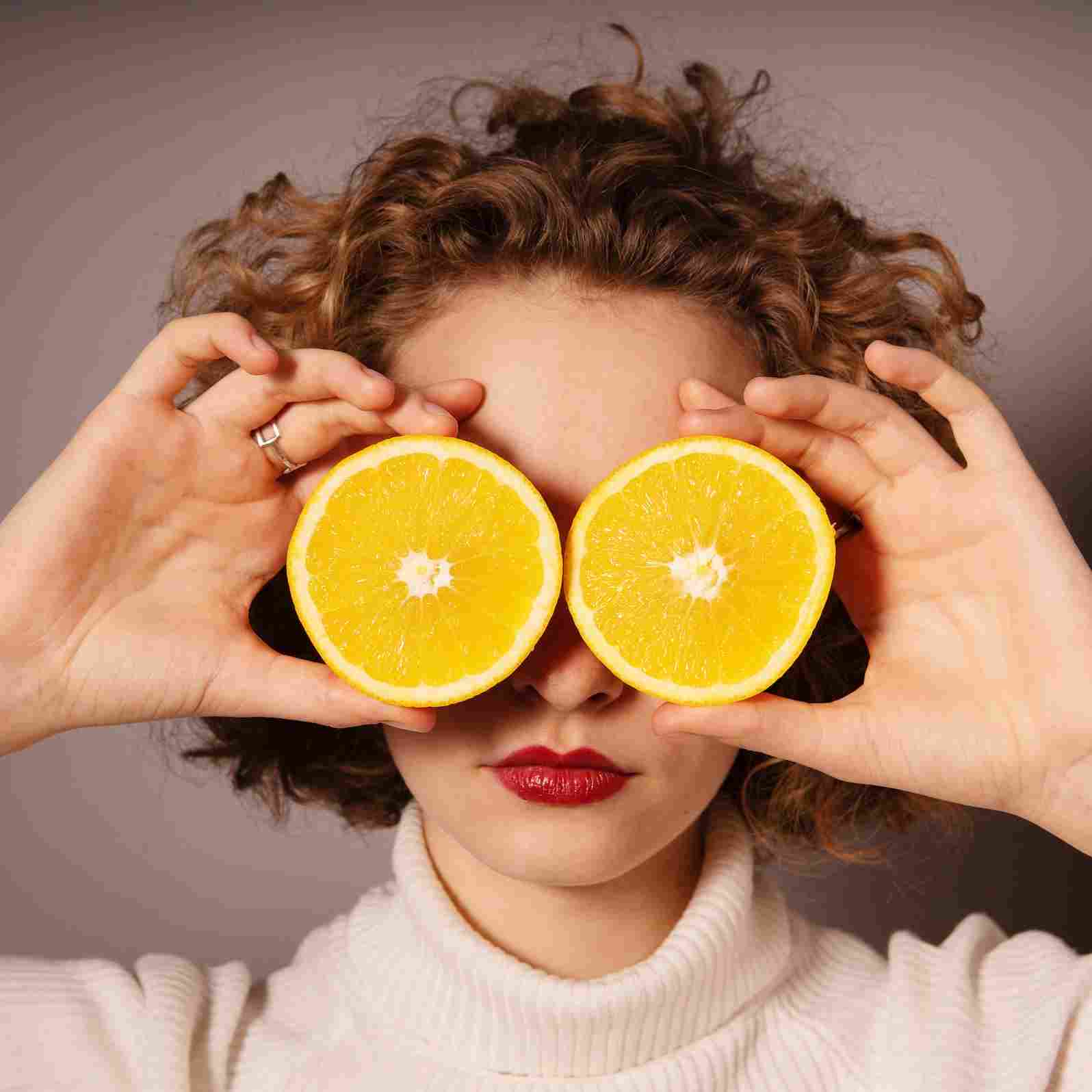 woman holding sliced orange fruit