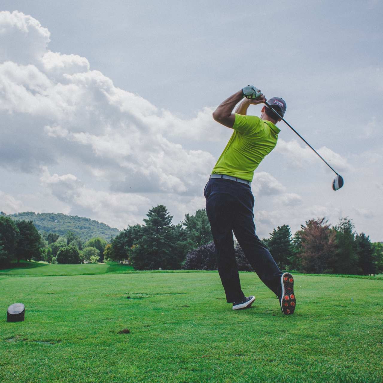 photo of man swinging golf driver