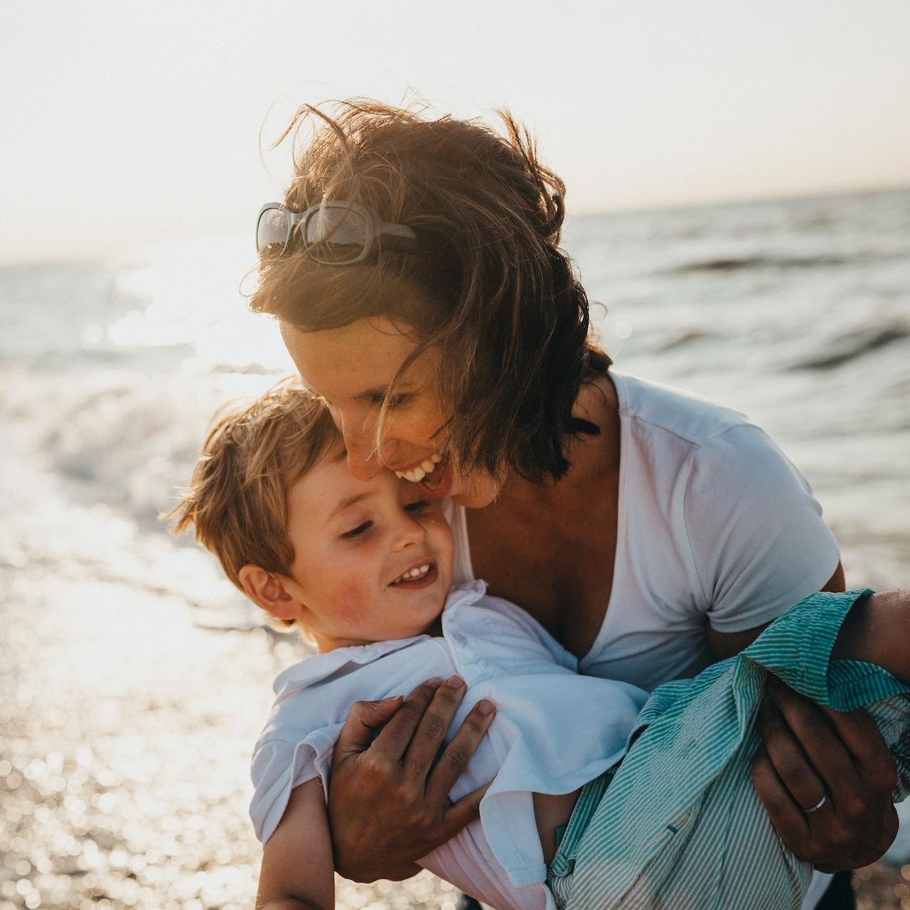 photo of mother and child beside body of water