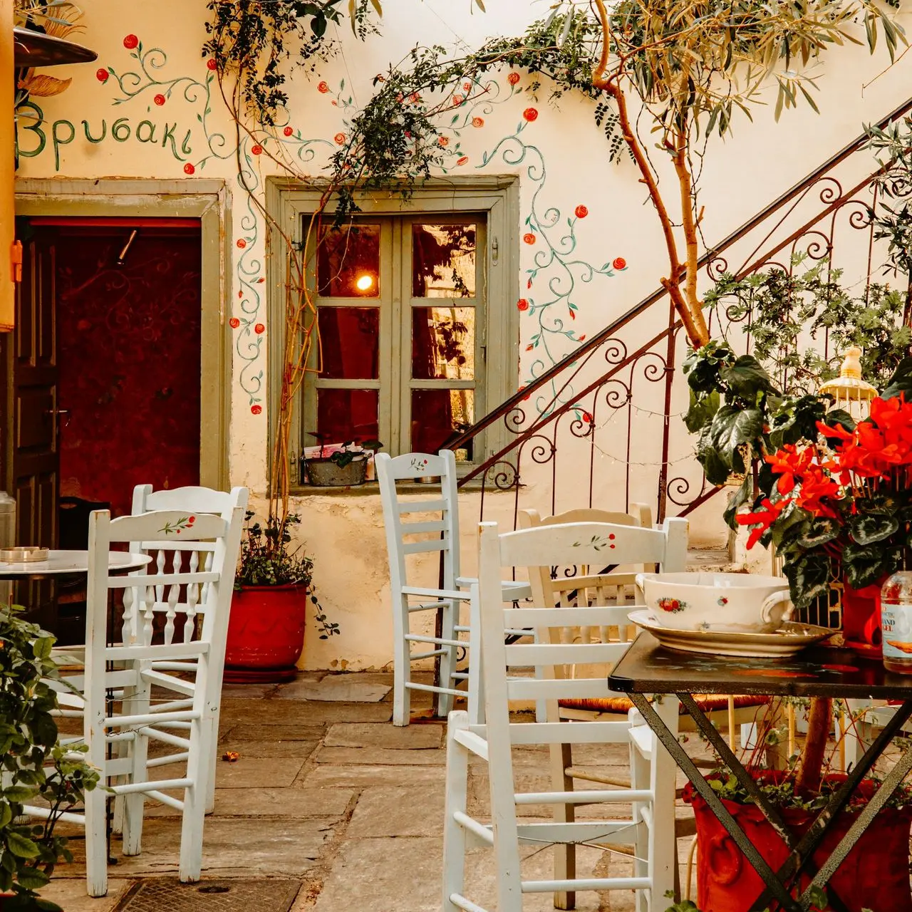 a patio with tables and chairs and potted plants